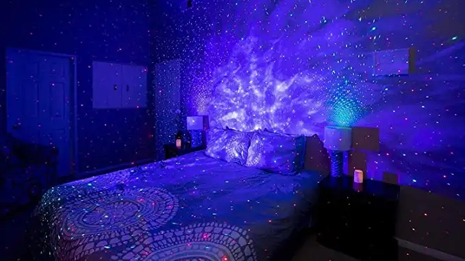 Galaxy projector projecting on bed and wall with purple and white lights