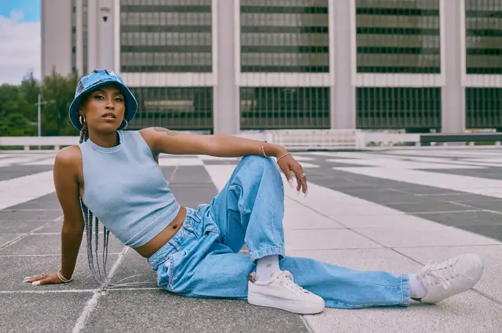 person posing in light wash wide leg jeans with white sneakers