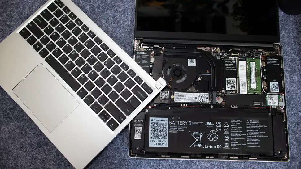 The keyboard lid lies atop the bare laptop parts.