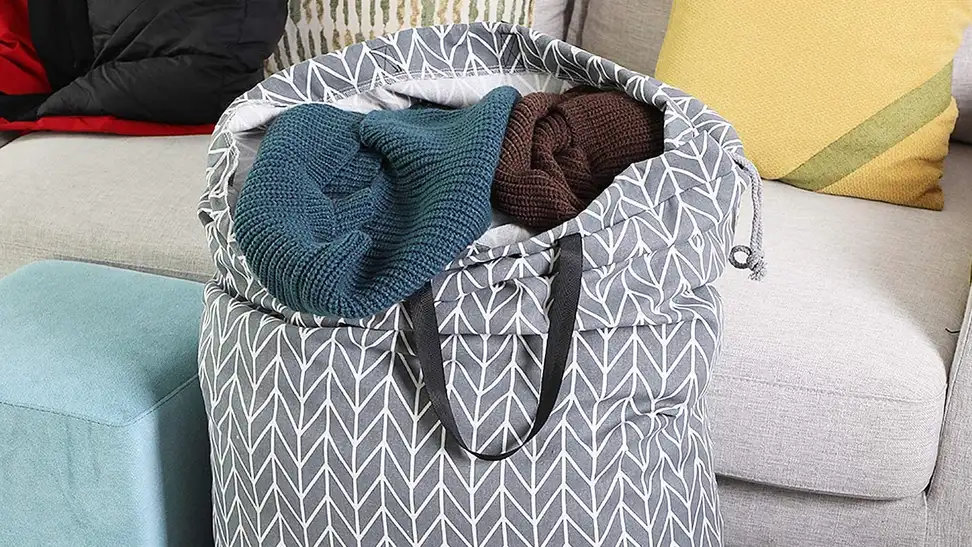 A full laundry bag sitting in a dorm room before the clothes in it go into the washer machine.