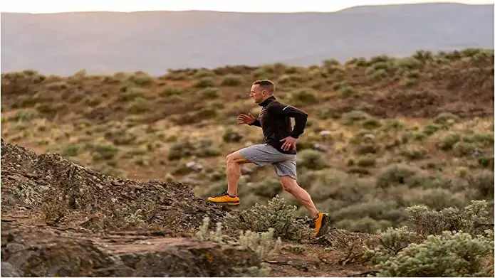 A trail runner moving on a trail on a ridge.