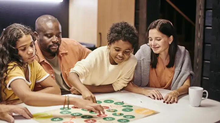 A family of four enjoys a board game together