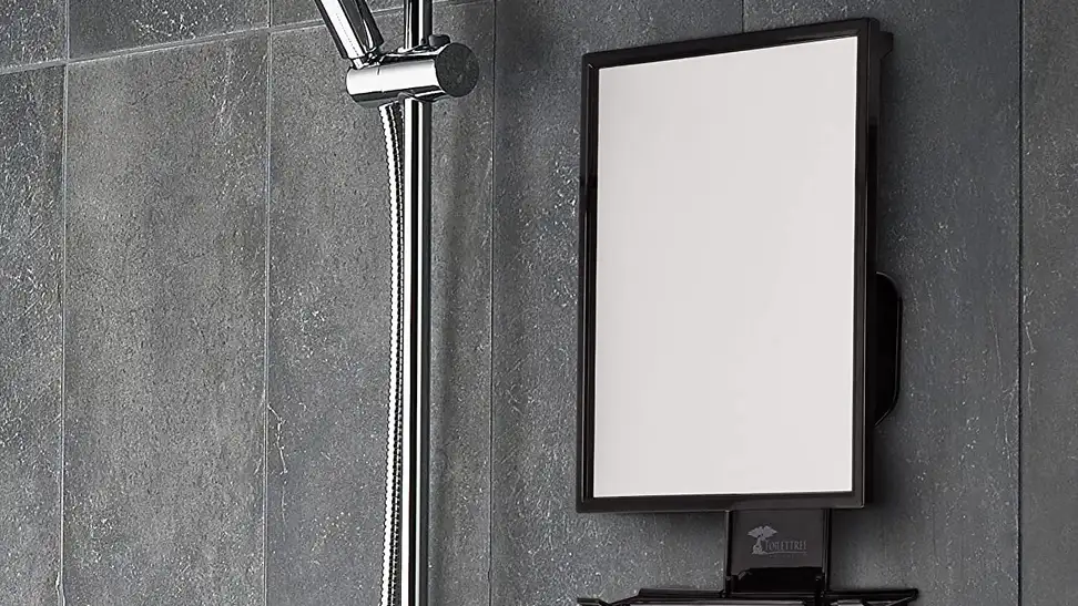 A fogless shower mirror being used for music and for a man to shave.