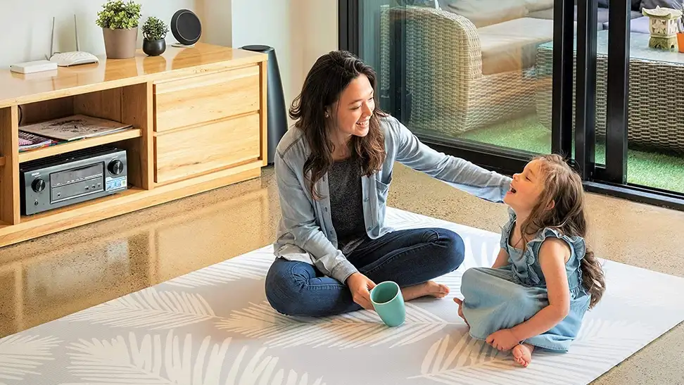 A parent and child enjoy playtime on a Cushmat play mat