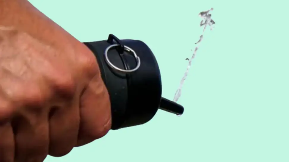 Hand holding black Tushy Travel bidet