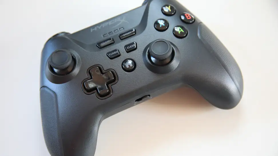 A black HyperX Clutch X-Box controller sits on a surface.