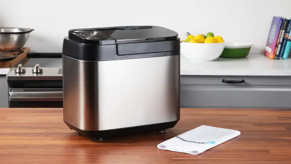 Panasonic bread maker sitting on wood counter.
