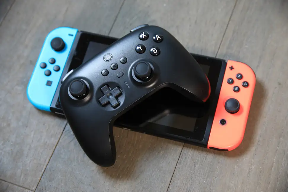 A black ultimate controller atop a nintendo switch