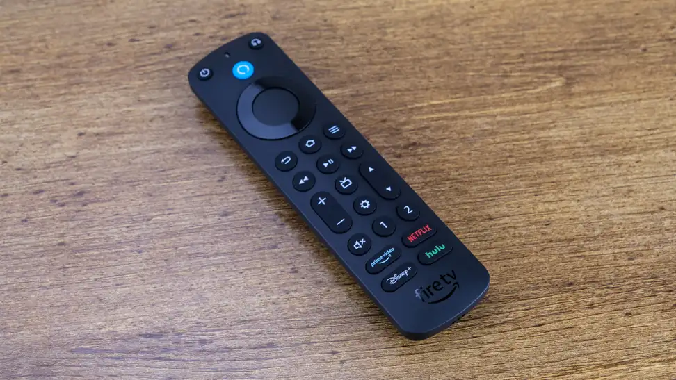 An Amazon Alexa Voice Remote Pro resting on a wood surface.