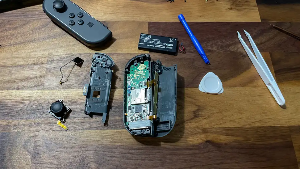 A pair of Nintendo Switch Joy-cons opened and being worked on to fix stick drift.