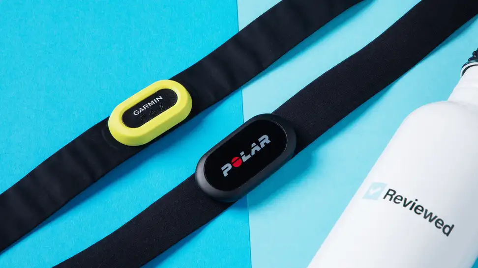 The Garmin HRM-Pro and the Polar H10 heart monitor side-by-side next to a Reviewed bottle.