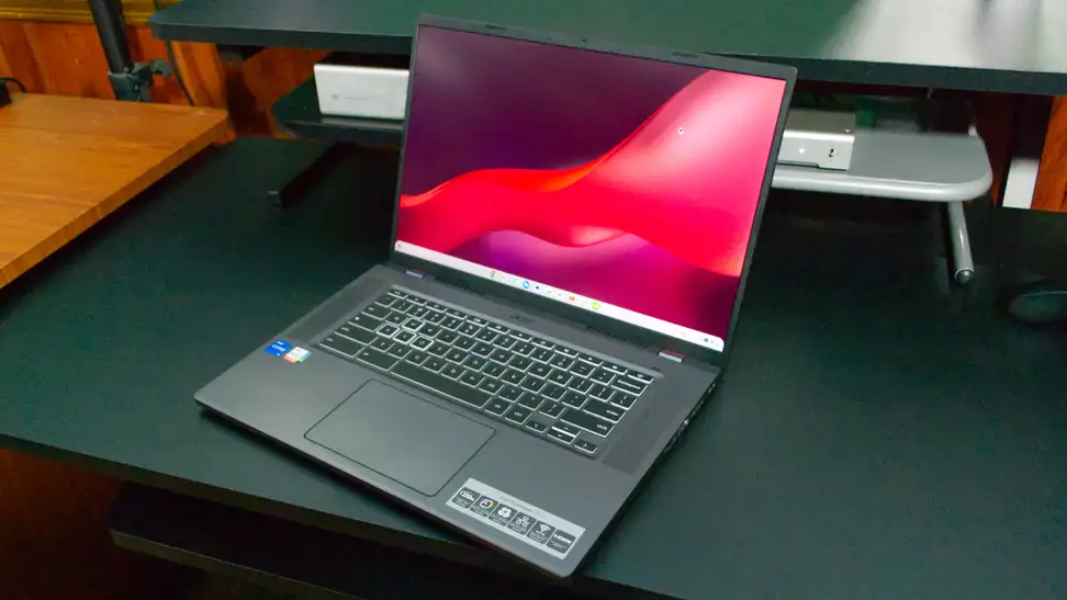 An open and powered on laptop on top of a black table