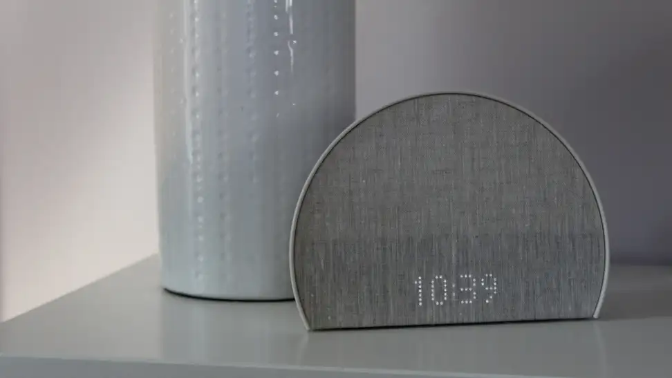 The Hatch Restore 2 sits on a nightstand, displaying the time