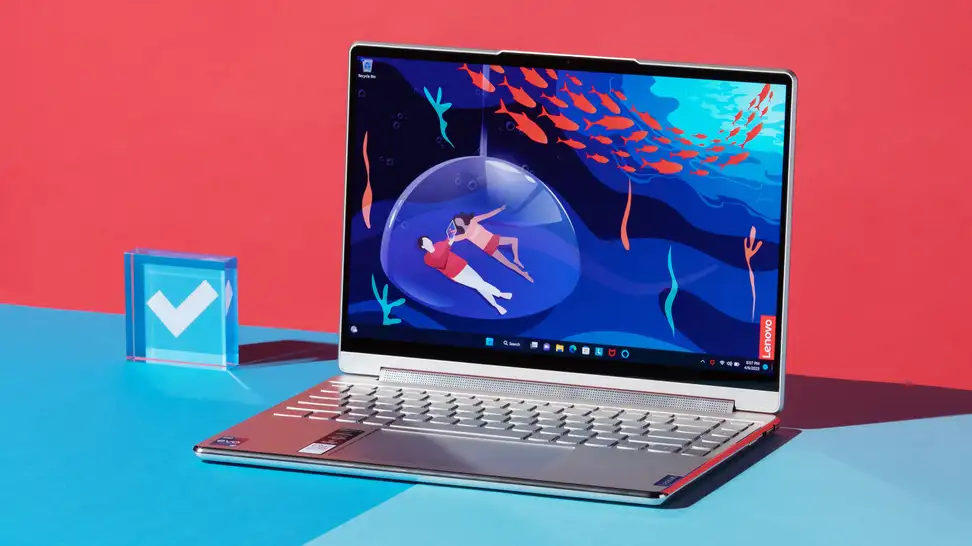 A silver laptop open and powered on against a blue and red backdrop.