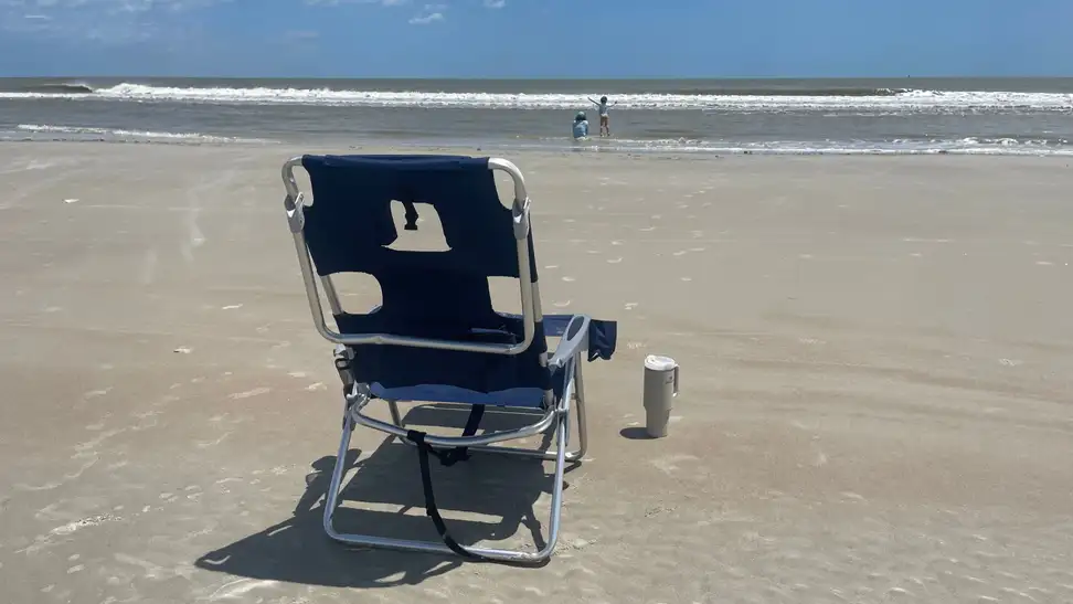 The Ostrich Backpack 3N1 Chair set up in the sun and sand at the beach