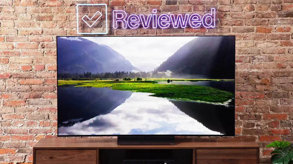 The LG C3 OLED TV in front of a brick wall with the Reviewed sign above.