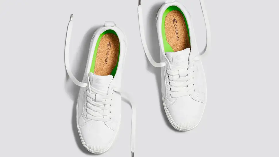 Cariuma white leather sneakers on a gray background