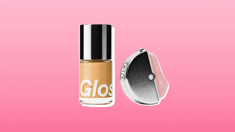 Glossier foundation and brush against a pink background.