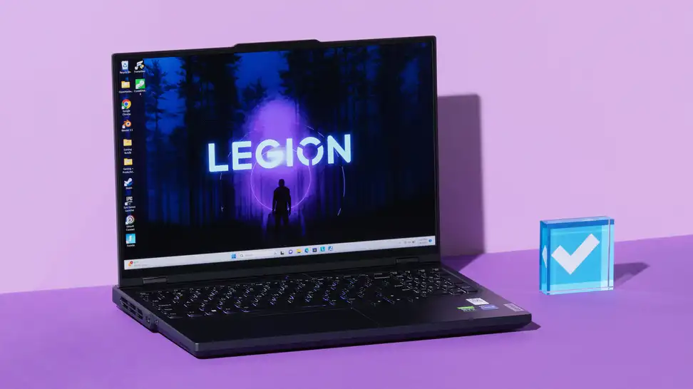 Black Lenovo Legion Pro 5i Gen 8 gaming laptop opened with desktop screensaver on screen next to blue acrylic paperweight in the middle of purple setting.
