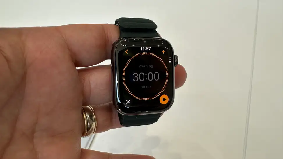 The Apple Watch Series 9 held around a person's fingers.