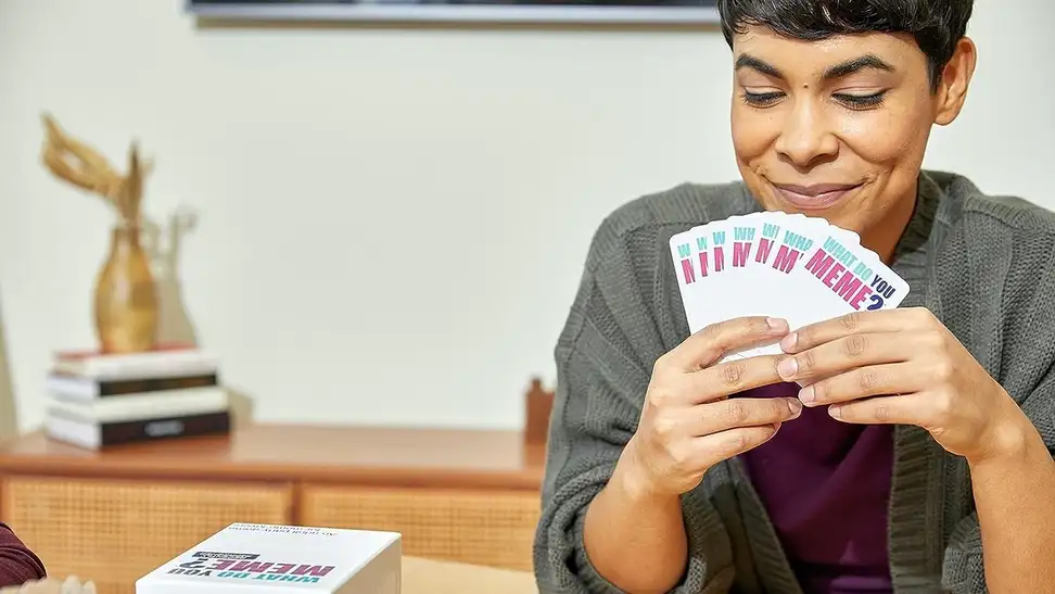 A woman playing 'What Do You Meme?' with her friends.