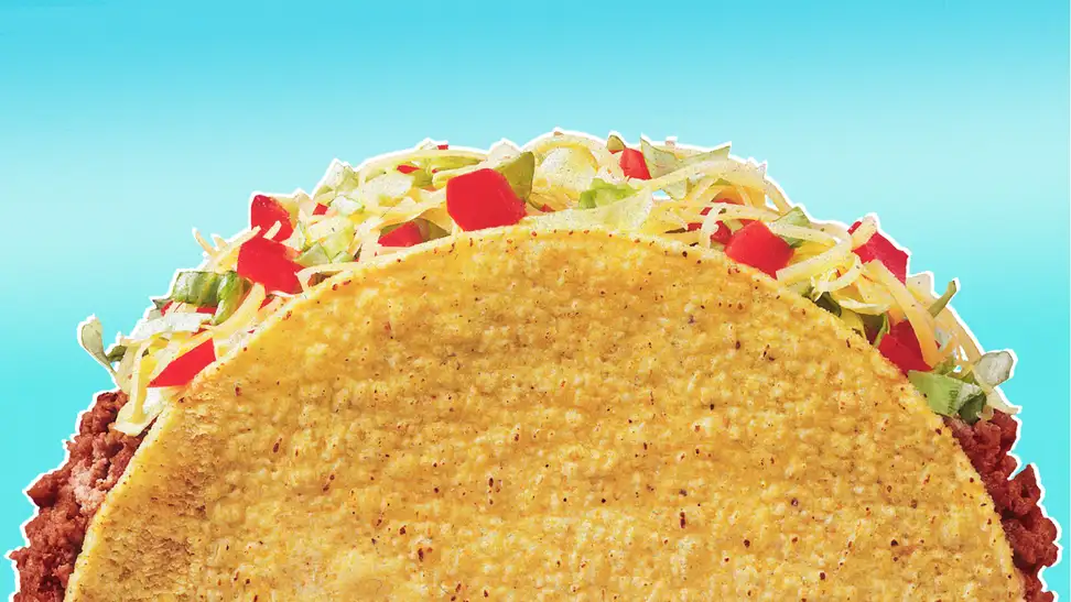 Hard shelled taco against blue background