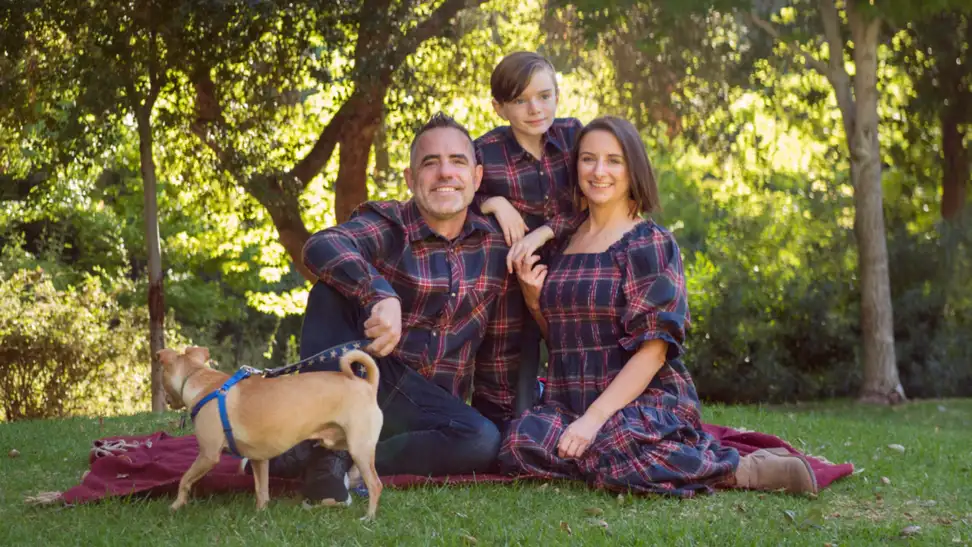 A family of three in Ivy City Co. plaid Madeline outfits in navy.