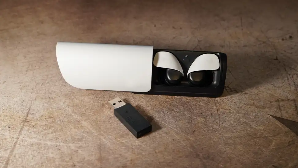 The Sony Pulse Explorer earbuds inside of their case above a USB dongle.