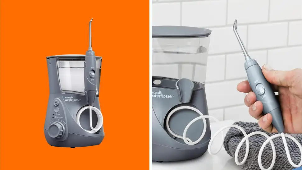 A Waterpik Aquarius water flosser in front of a colored background next to a hand holding the main flossing tool.