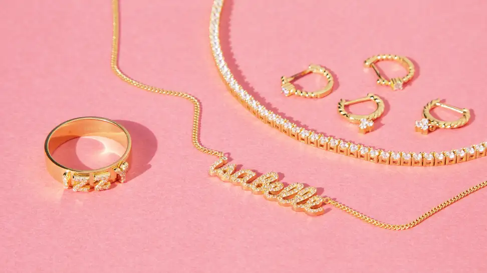 gold jewelry on pink background