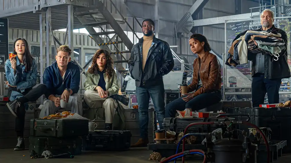 Cast of "Lift" standing in a warehouse.