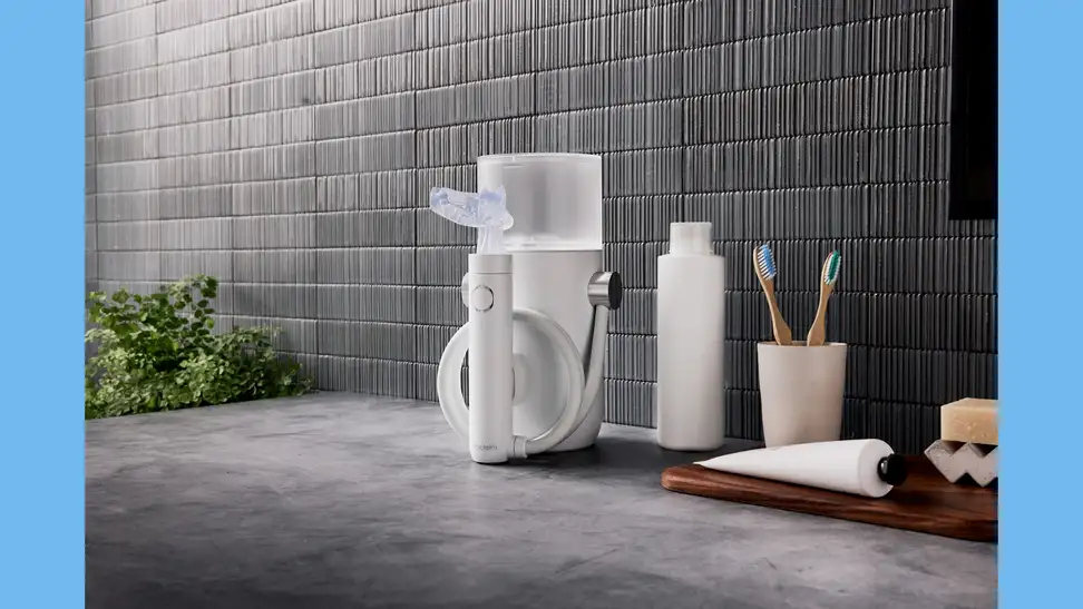The Proclaim Custom-Jet Oral Health System sitting on a countertop, attached to its Hydro Station base.