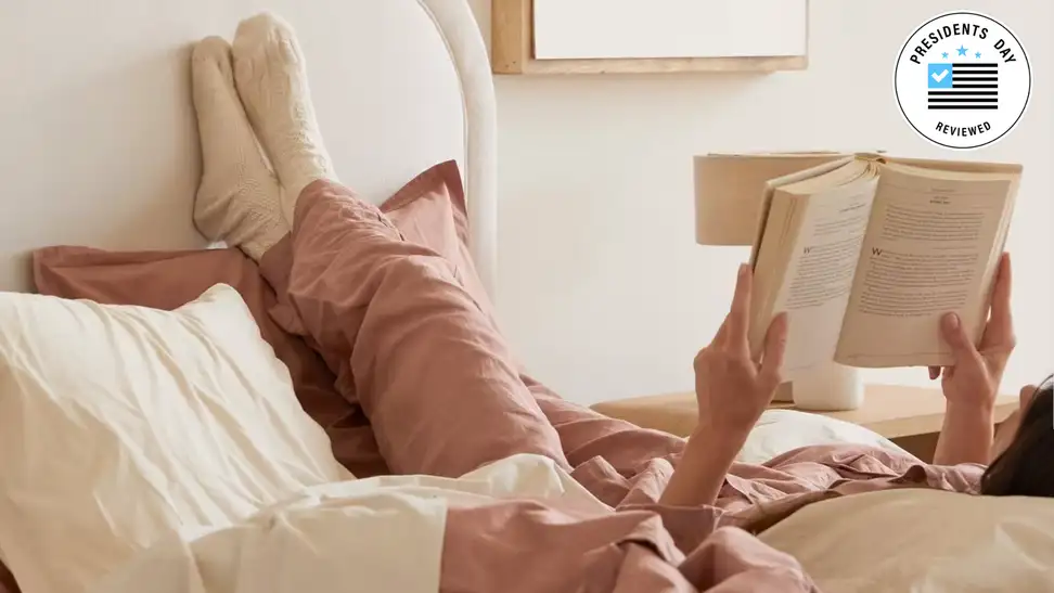 A woman reading a book with Parachute clothing on.