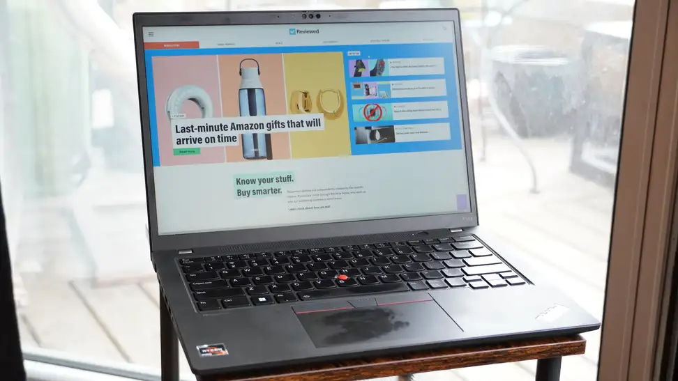 Lenovo ThinkPad P14s Gen 4 opened up with internet browser on screen in front of large window.