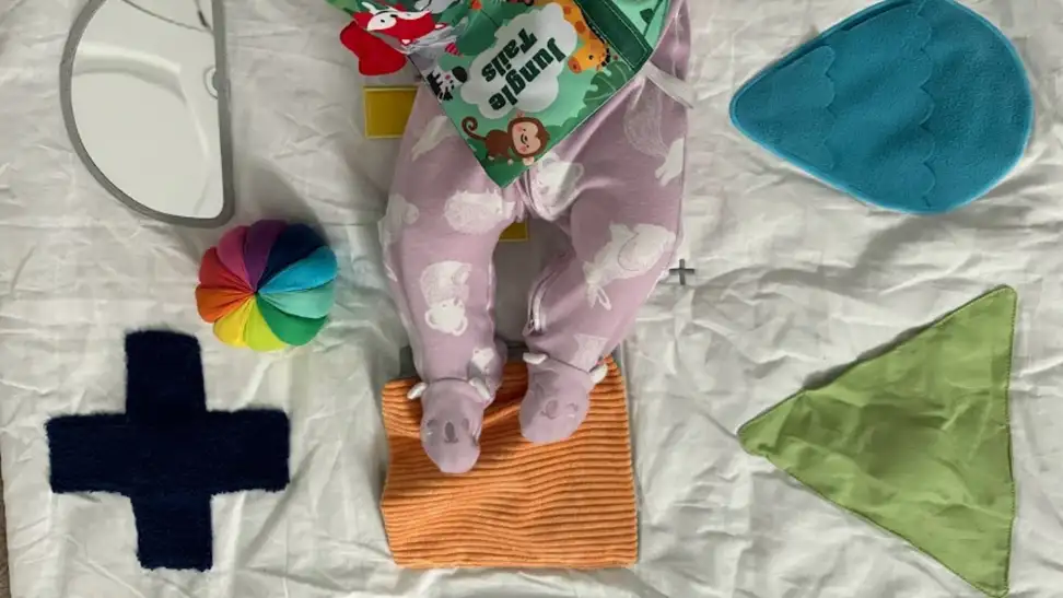 Baby legs on a KiwiCo playmat