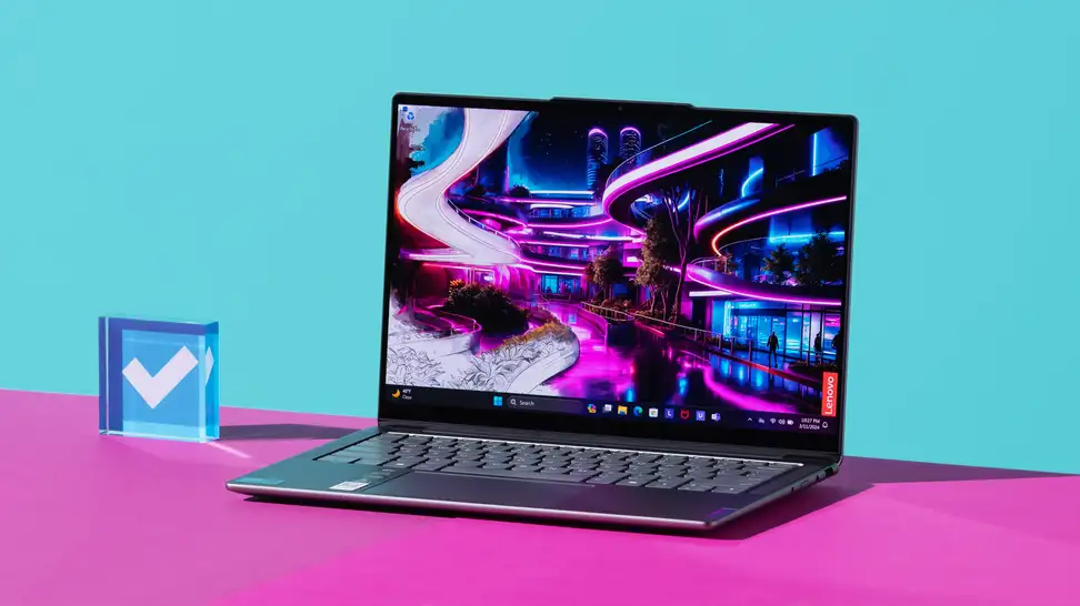The Lenovo Slim 7 with a abstract wallpaper on screen on top of a purple desk next to a blue paper weight.