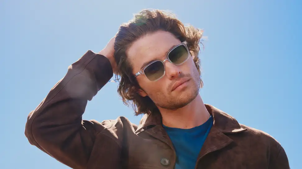 Chase Stokes Outer Banks actor wearing sunglasses and brown jacket