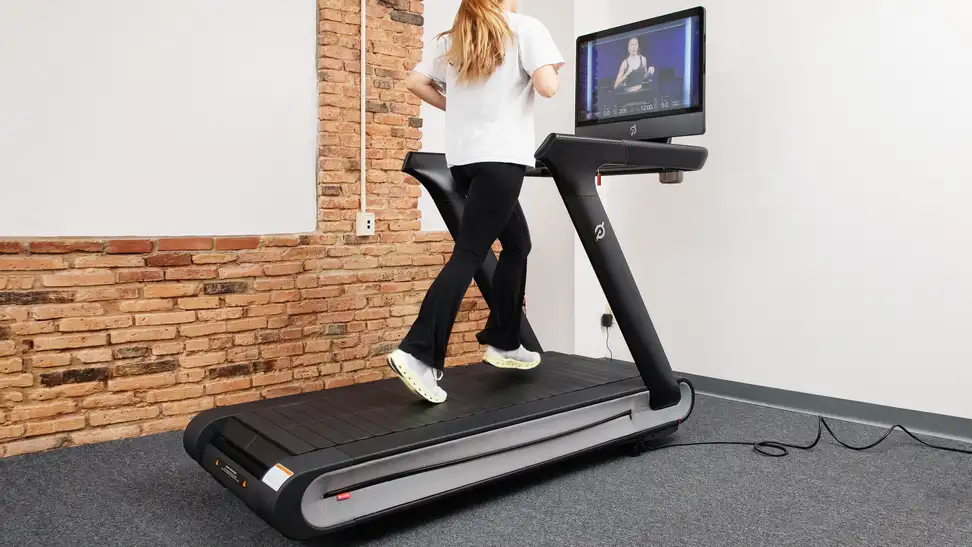 A woman running on Peloton Tread+