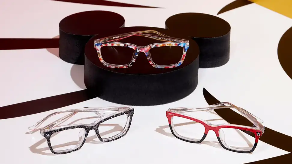Three pairs of Pair Eyewear glasses on a black Mickey Mouse table.