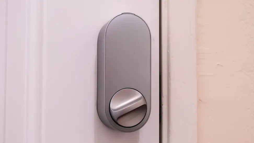 The Aqara U200 smart door lock shown in silver hanging on a white door.