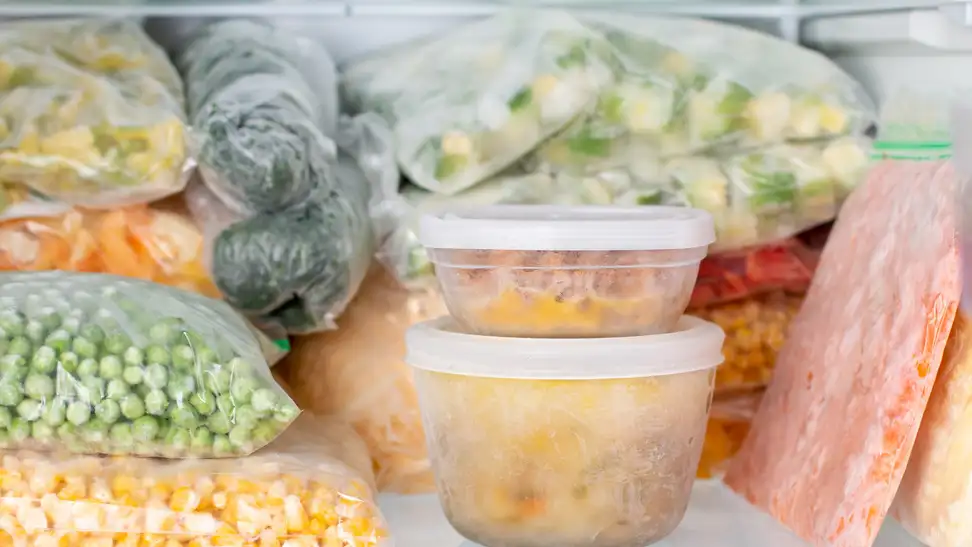 A neatly stacked freezer full of frozen vegetables