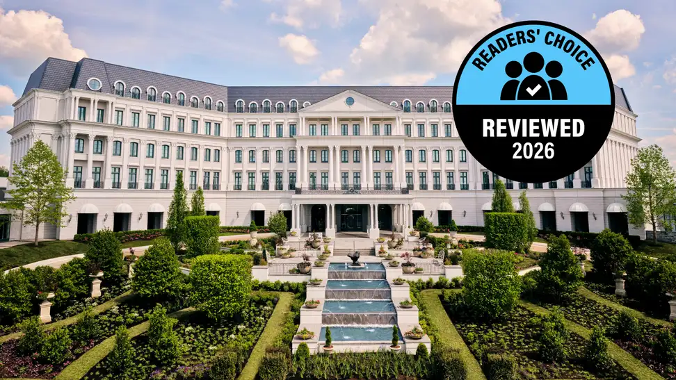A large, grand hotel with lush gardens in front of it