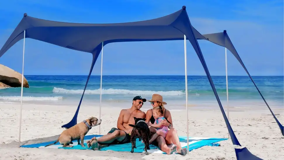Beach tent propped up in sand outdoors.