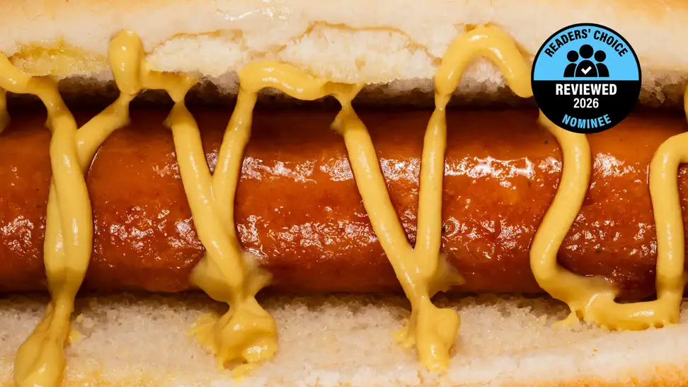 A close up of a hot dog with a squirt of mustard