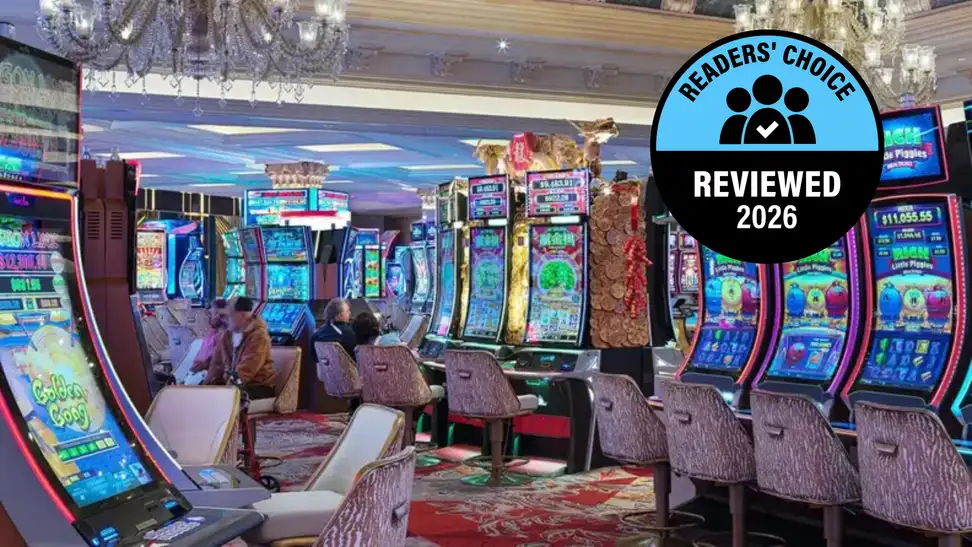 Casino floor lined with colorful slot machines and gaming chairs.