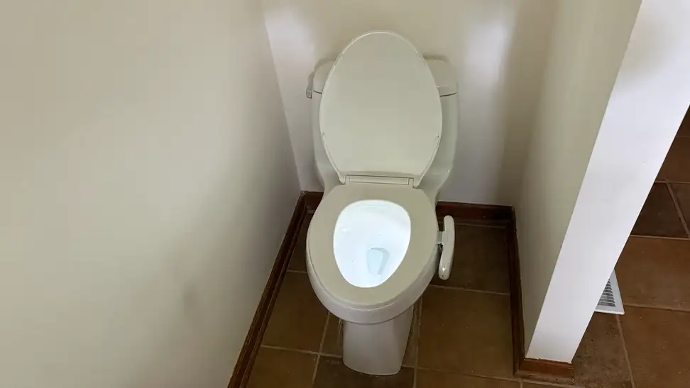 White toilet in front of white walls with the Kohler Dekoda installed in the right side, with the toilet bowl illuminated.