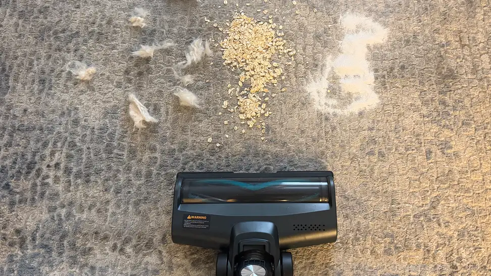 Yaber H20 cordless vacuum being used on carpet to pick up various debris.