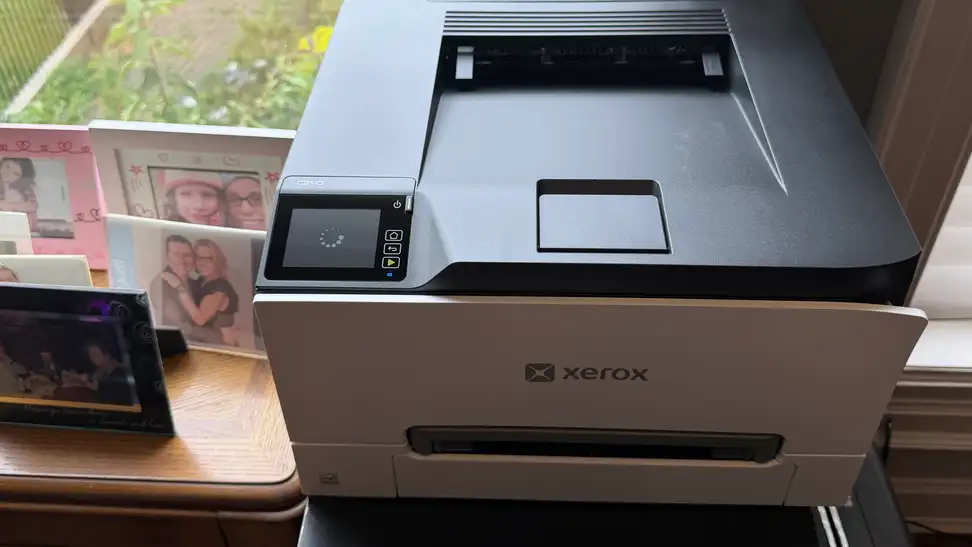 A Xerox color printer next to photo frames