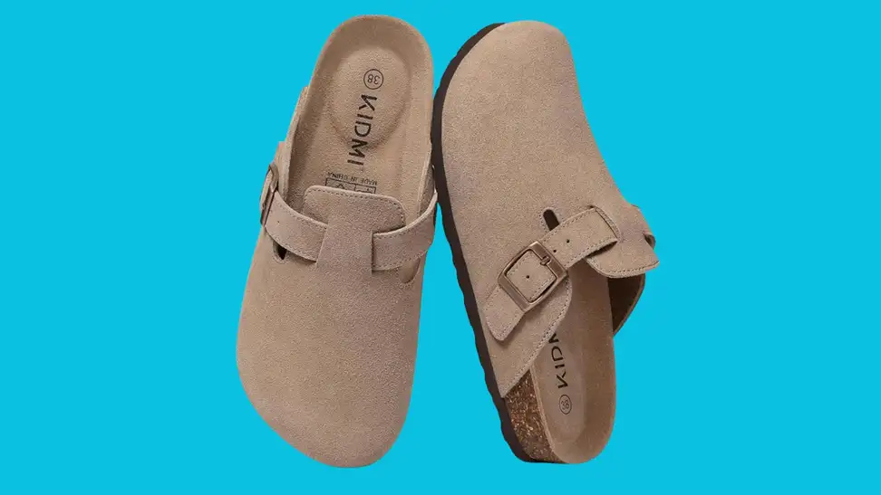 A pair of tan suede clogs silhouetted against a blue background.