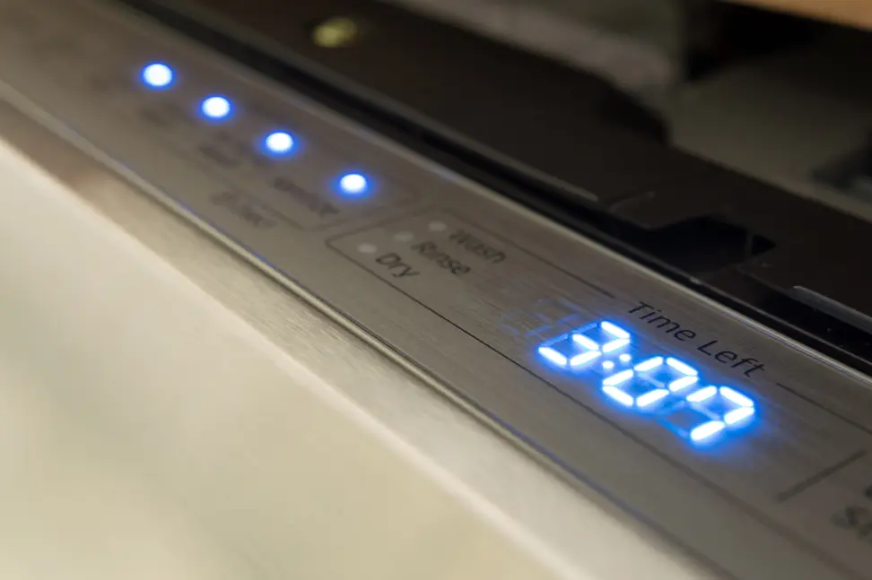 The control panel glows in blue when the dishwasher is operating